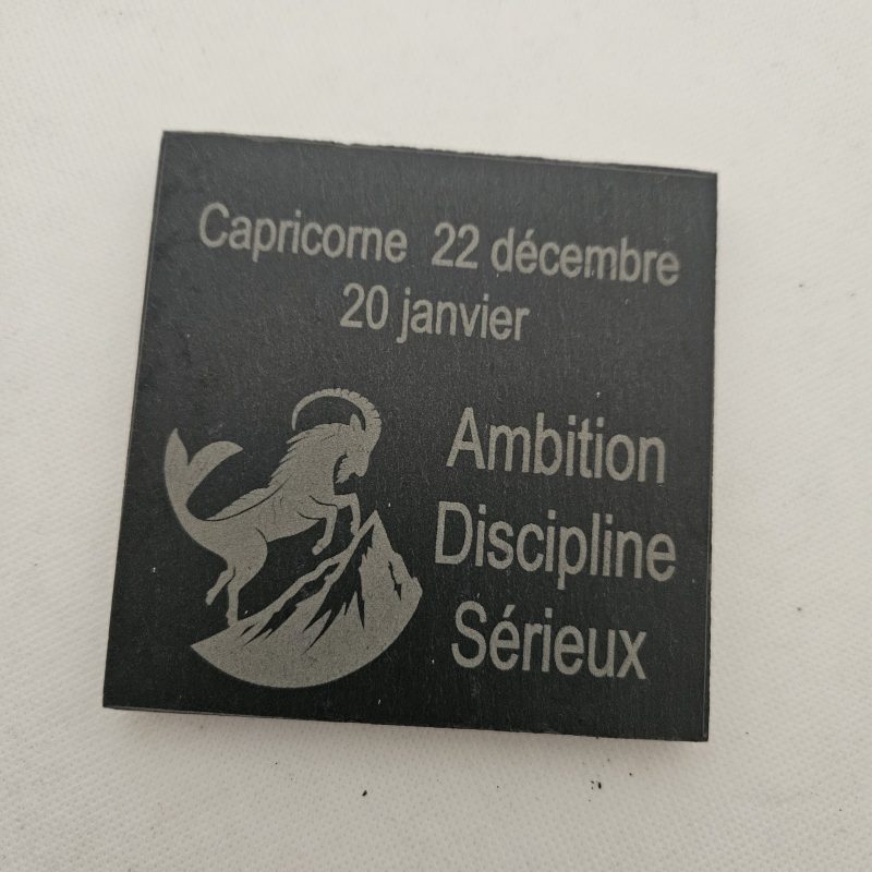 Dessous de verre en ardoise gravé au laser, représentant le signe astrologique du Capricorne, accompagné des mots "22 décembre – 20 janvier", "Ambition", "Discipline" et "Sérieux".