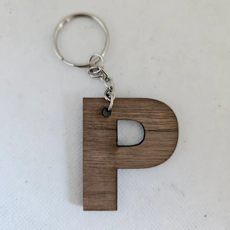 Porte clé en bois noyer la lettre P découpé au laser attaché à un anneau métallique