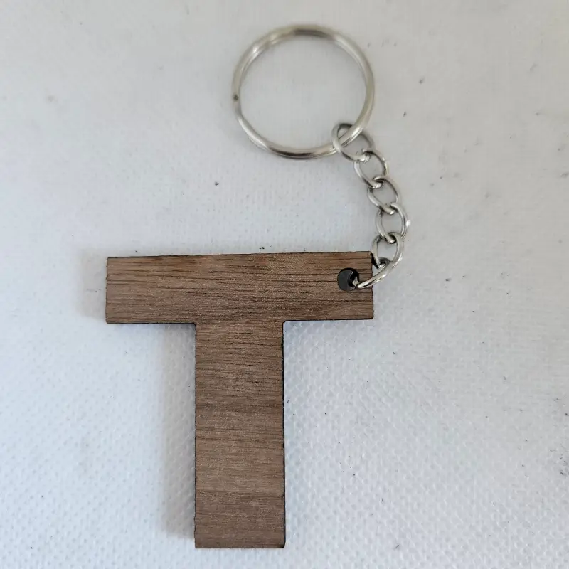 Porte clé en bois noyer lettre T découpé au laser attaché à un anneau métallique