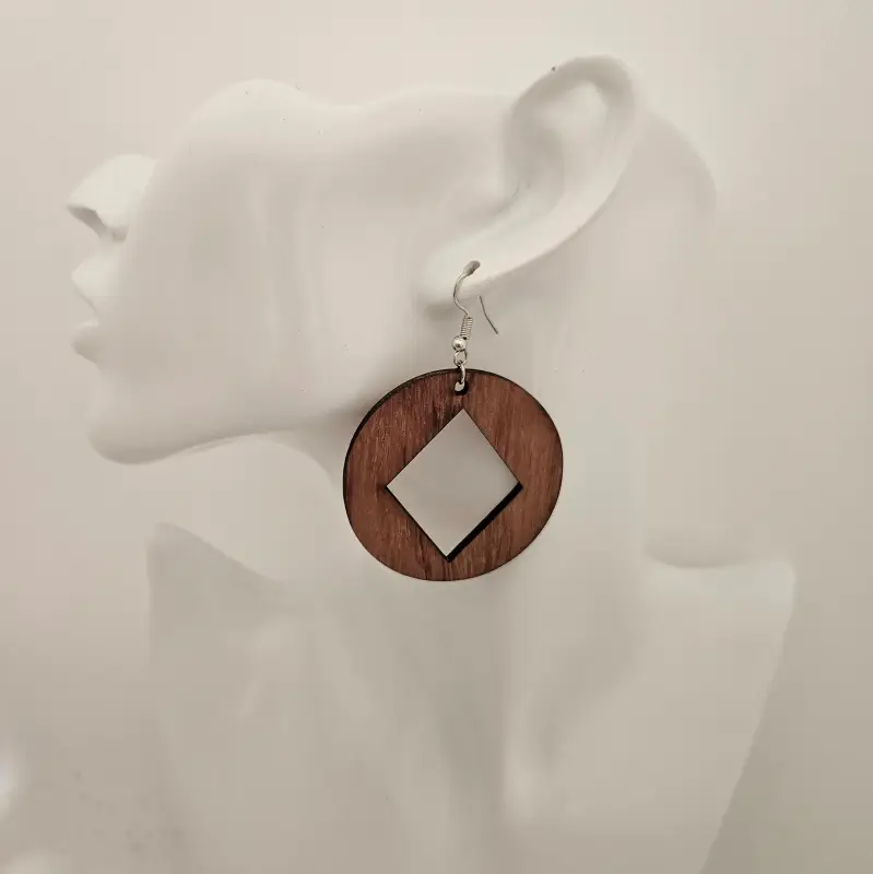 Boucle d'oreilles ronde découpée au laser avec au centre un losange découpé. Présentée sur un buste.