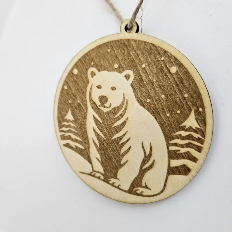 Boule de Noël découpée et gravée au laser "un ours, des flocons et des sapins gravés"