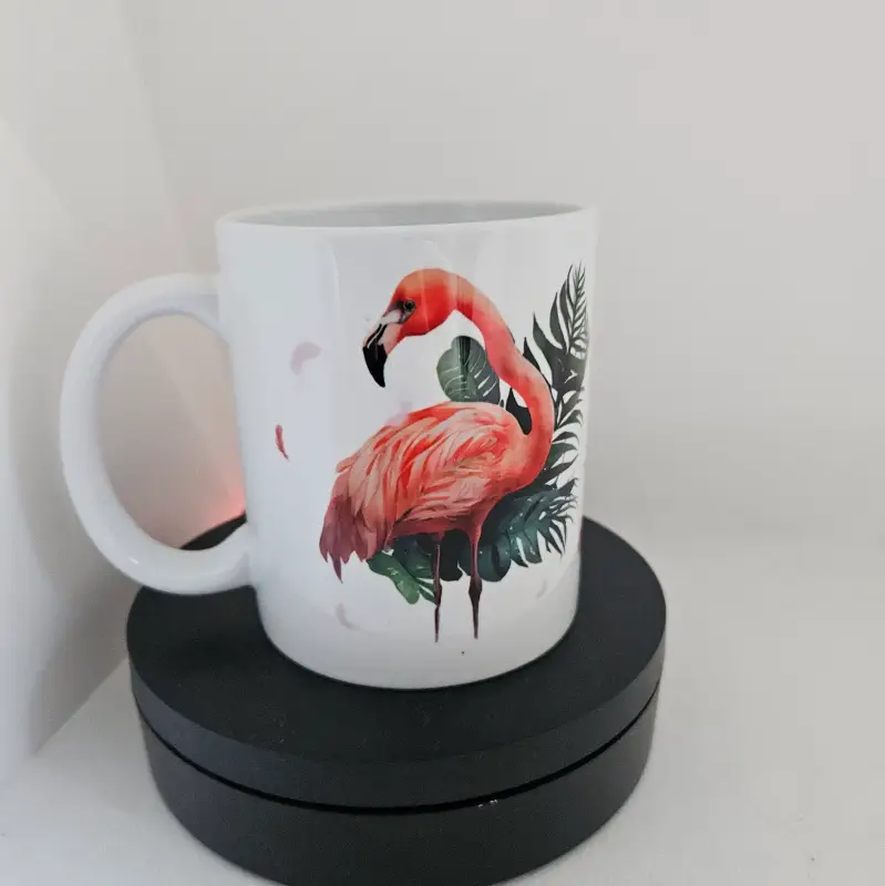 Tasse avec un design flamant rose avec du feuillage autour et des plumes qui volent
